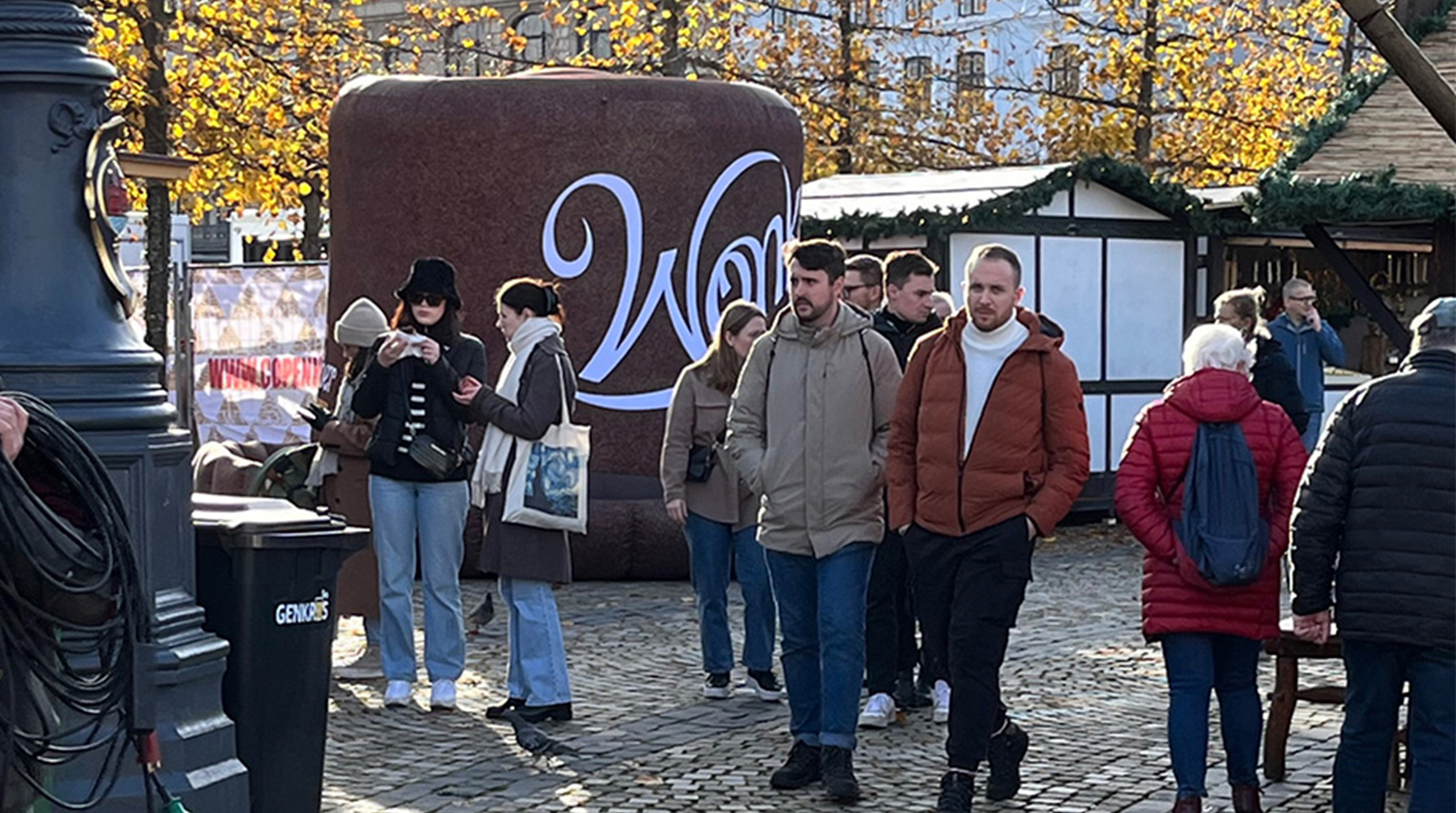 Willy Wonkas oppustelige hat oplyst i aftenens skumring på Kongens Nytorv, med julelys og en livlig menneskemængde.